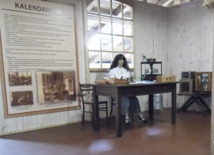 Labolatorium oceny nasion, kobieta siedząca przy stole, na ścianie tablica z kalendarium