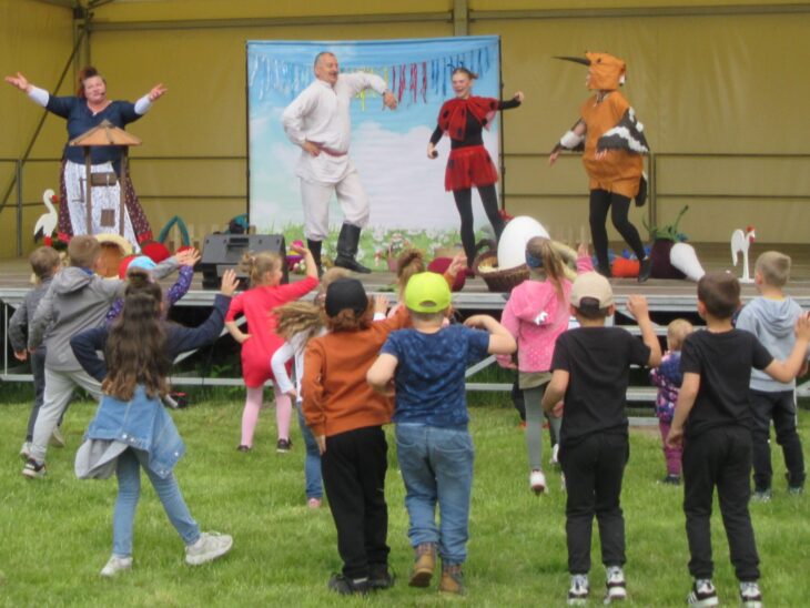 Przedstawienie w Muzeum. Artyści tańczą na scenie. Pod sceną tańczą dzieci.