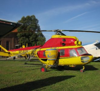 podwórze i czerwono żółty helikopter do agrolotnictwa
