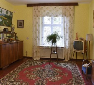 gorzelnia w szreniawie stary pokój z dywanem na podłodze i drewnianymi starymi meblami