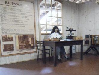 Labolatorium oceny nasion, kobieta siedząca przy stole, na ścianie tablica z kalendarium